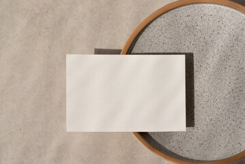 Minimalist business brand template, blank paper card mockup on ceramic plate, on beige stone...