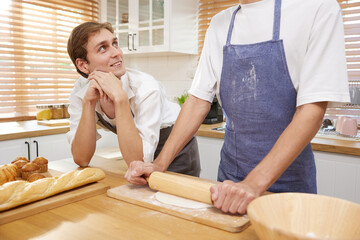 LGBT gay couple making a bread together in the kitchen
