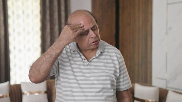 Fat Indian old man having headache