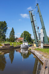 Boat in a canal with an open road bridge