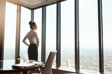 Business woman, office window and thinking of ideas, plan or vision in city building. Professional female entrepreneur person with hands on hips for motivation or inspiration for corporate career