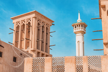 Al Fahidi mosque minaret and traditional arab windtower used for ventilation and air conditioning at historical district and neighbourhood in Bur Dubai