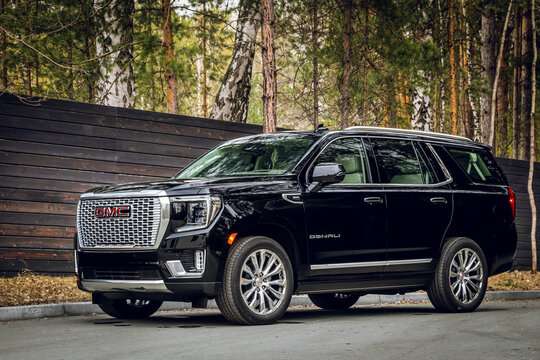  Novosibirsk, Russia - April  25, 2023: black GMC Yukon Denali SUV parked in  forest, side view