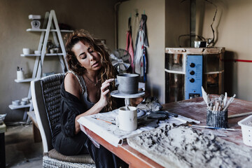 latin young woman working with clay pot in workshop and ceramic business entrepreneurship in Mexico Latin America, hispanic female