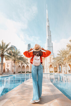 18 January 2023, Dubai, UAE: Rear view of the traveler girl with backpack as she takes in the incredible view of the Burj Khalifa and the Dubai skyline.