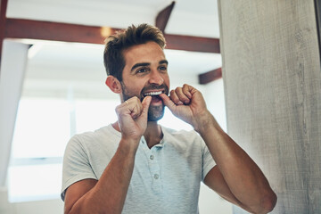 Dental, floss and teeth with man in bathroom mirror for cleaning, morning routine and oral hygiene....