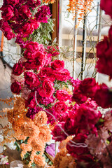 Arch decorated pink, orange flowers roses for birthday party in banquet area, hall. Wedding reception for luxury ceremony. Decoration of event. Closeup decor detail. Photo wall, arch