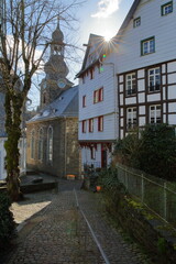 The historical center of the medieval town of Monschau, North Rhine Westfalia, Germany, with half timbered houses, narrow streets and the bell tower of the Evangelical City Church