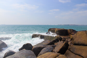 Stone seashore in Sri Lanka. Unawatuna beach, dark brown rocks, background, copy space for text