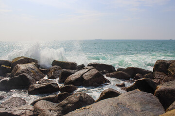 Stone seashore in Sri Lanka. Unawatuna beach, dark brown rocks, background, copy space for text