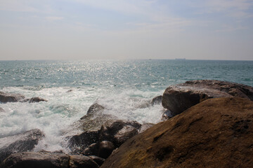 Stone seashore in Sri Lanka. Unawatuna beach, dark brown rocks, background, copy space for text