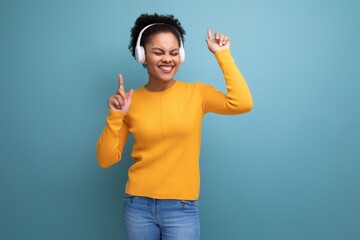 cheerful young hispanic business woman with black curly hair listening to music in white headphones
