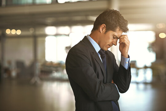 Headache, stress businessman standing and at his office sad or upset at debt fail at work. Mental health or anxiety, burnout and exhausted or depressed male corporate worker frustrated and tired