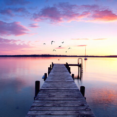 Obraz na płótnie Canvas sunset on long jetty at lake