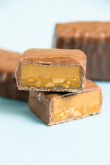 Delicious chocolate bars with salted caramel on a blue paper background