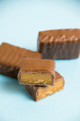 Delicious chocolate bars with salted caramel on a blue paper background