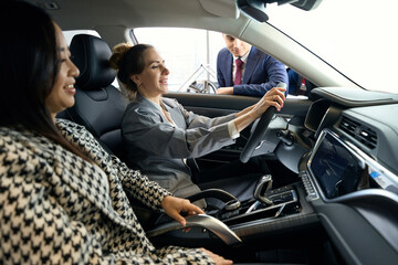Two happy women sitting on front seats in car