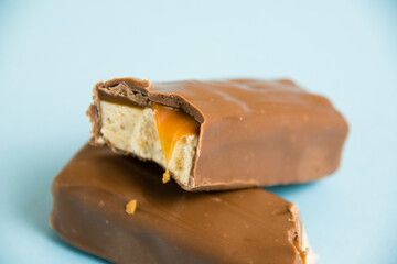 Tasty chocolate bar with white nougat and caramel on a blue background