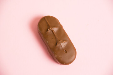 Flatlay, delicious chocolate bar on pink paper background