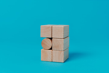 cylindrical toy block between square toy blocks