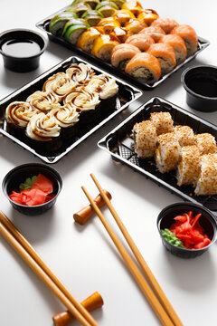 Set of sushi rolls in plastic packages on a white background.