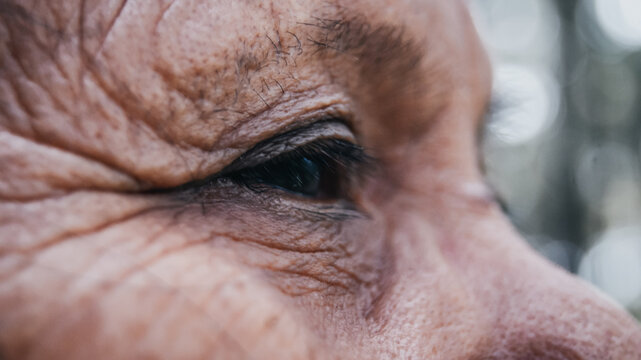 Photo of an old female's eye that looks like fills with hope but still hopeless and tired at the same time. Look at the future, and remind the past.