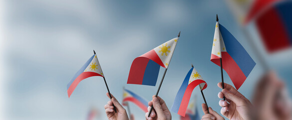 A group of people holding small flags of the Philippines in their hands - 601637474