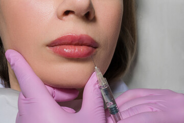 Close up portrait of woman getting botox cosmetic injection in the lips. Beautiful woman gets botox injection in her face. Adult girl gets cosmetic injection of botox in a clinic. Beauty treatments