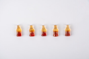 Cola flavored gummy jellies in the shape of cola bottles,isolated over white background.