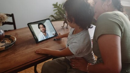 Virtual doctor visit: Mother and son consulting a doctor online using a tablet - Powered by Adobe