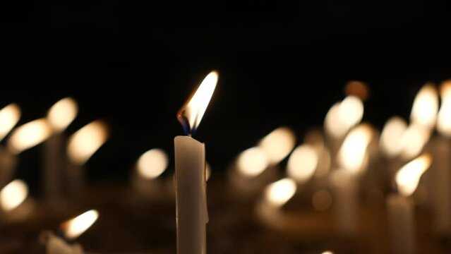 Candles burning at night. Many candles flickering with illumination lighting the dark