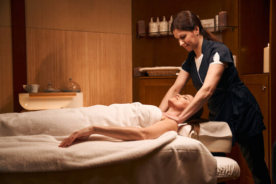 Skilled physiotherapist relaxing tight pectoral muscles in adult woman