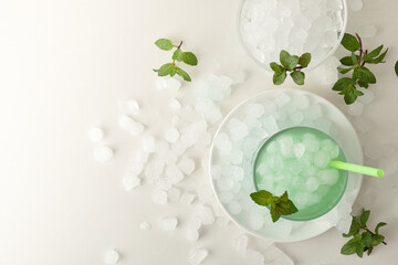 Background with mint drink on white table filled with ice