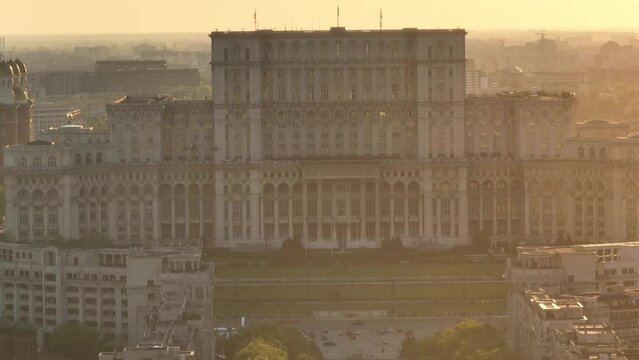 Exterior View Of Palace of the Parliament Atop Dealul Spirii With National Cathedral During Sunset In Bucharest, Romania. - aerial