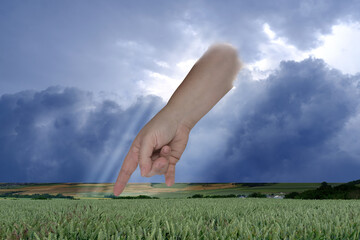 female hand points with index finger, dramatic thunderstorm sky with dark clouds, concept of God's...