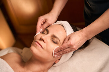 Obraz na płótnie Canvas Experienced beautician preparing spa customer for beauty treatment