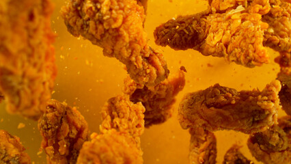 Freeze Motion Shot of Flying Fresh Fried Chicken Wings or Strips, Close-up