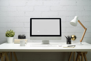 Creative workspace with blank computer desktop, lamp, camera and potted plat. Business presentation, banner website