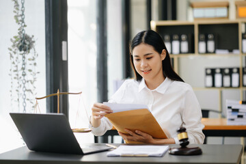 Beautiful asian woman lawyer working and gavel, tablet, laptop in front, Advice justice and law concept.