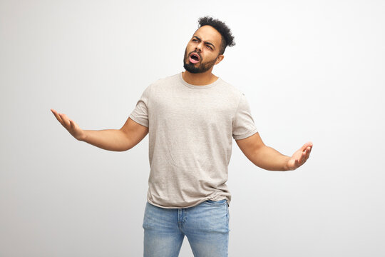 surprised confused man saying what the fuck on white background wearing t shirt, isolated on white background