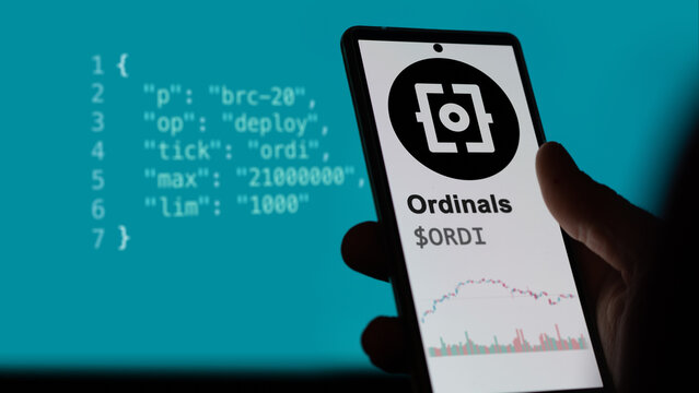 Ordinals token BRC 20 on a phone. $ORDI asset trend on a sreen. BRC-20 ordinals crypto concept script on the background.