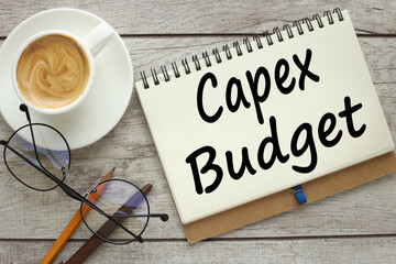 top view of a cup of coffee and a notepad with text CAPEX BUDGET - obrazy, fototapety, plakaty