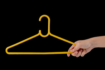 Hand and plastic clothes hanger isolated on black background 