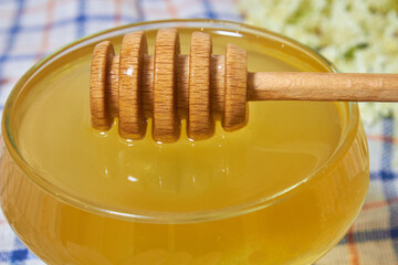 wooden stick in honey,close-up wooden spoon spindle in honey lies