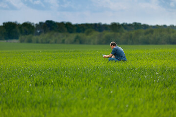 A young agronomist inspects the crops. Yield increase. The problem of world hunger. Organic cultivation of crops.Agriculture