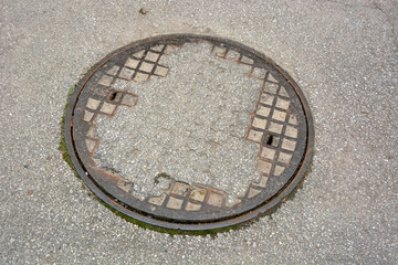 Old manhole patched with asphalt, septic tank inlets, sewage system