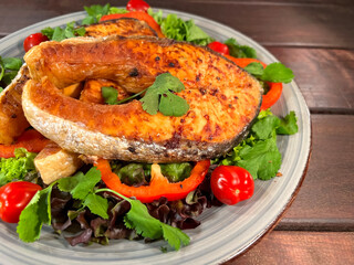 Salmon steak with vegetables in a plate
