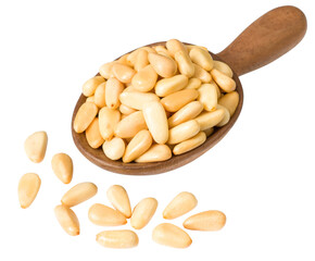 Roasted pine nuts in the wooden spoon, isolated on the white background.