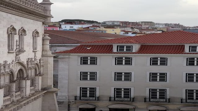 Panoramic view from Rossio Train Station tracking segull flying from one roof to another in Lisbon, Portugal. Vertical video