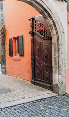 Timeless Stone Arch with Ornate Wooden Gates and Metal Decorations in Ulm's Historic District